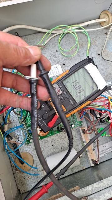 Braemar Gas Heater technician testing electronic parts using a digital multi meter