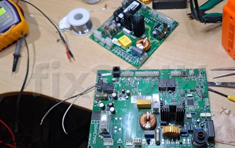 two Braemar heating electronic-control boards laid on fix2QIK's work-bench for repairs